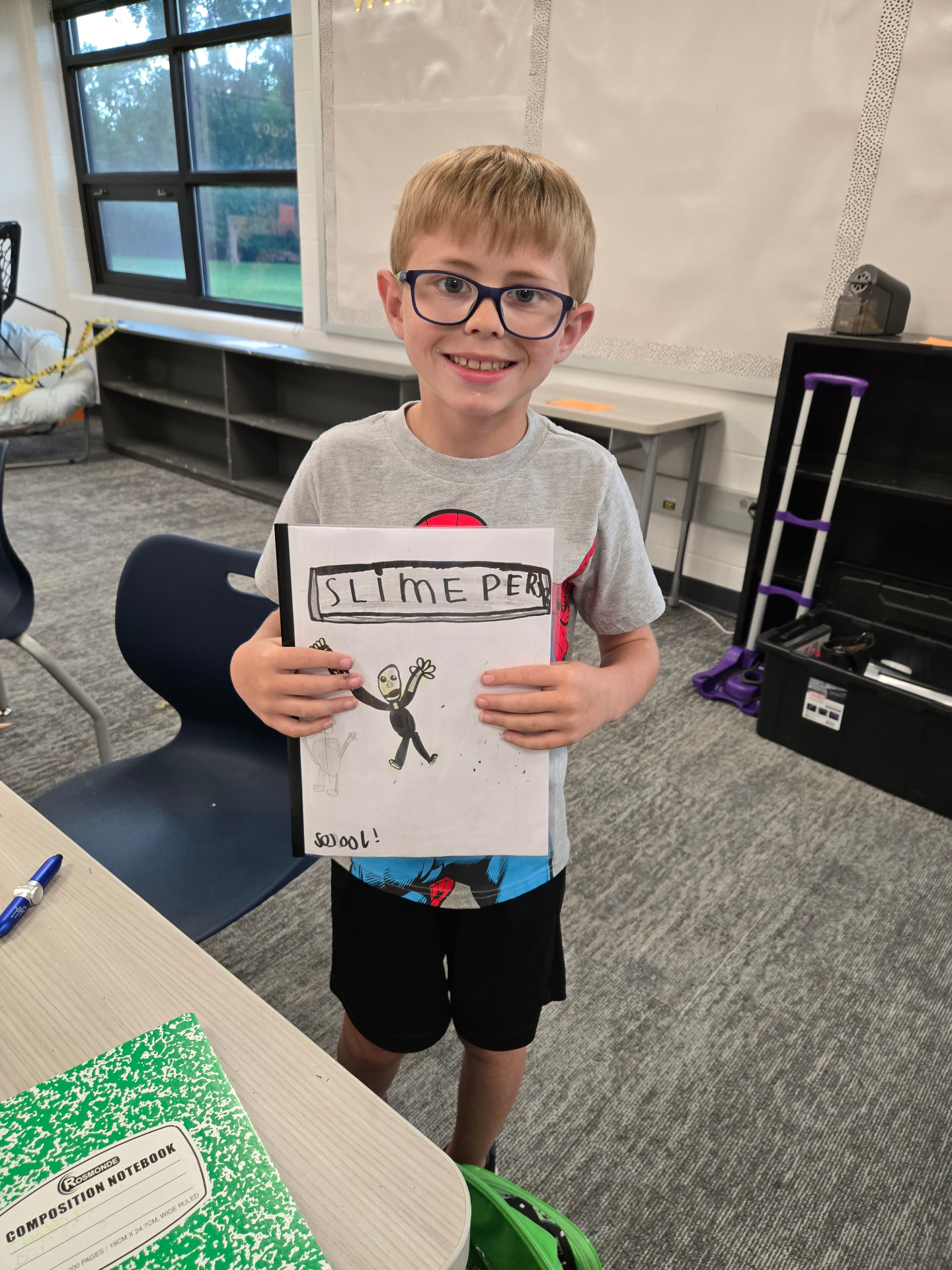 Student proudly showing a comic book created during a Recreation Academy club