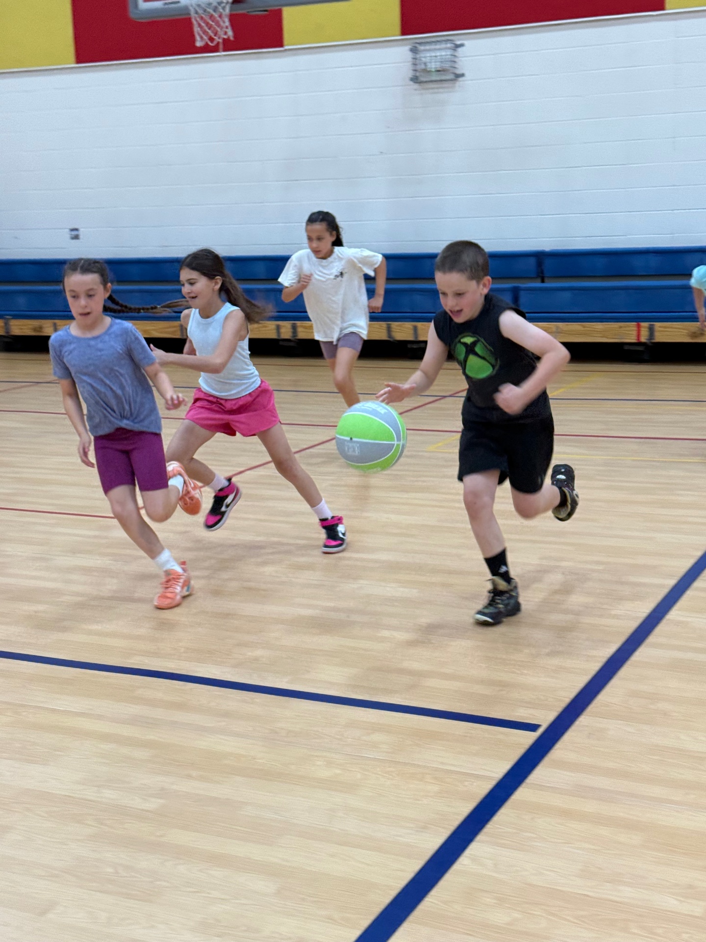 Kids chasing the ball during a Recreation Academy basketball clinic