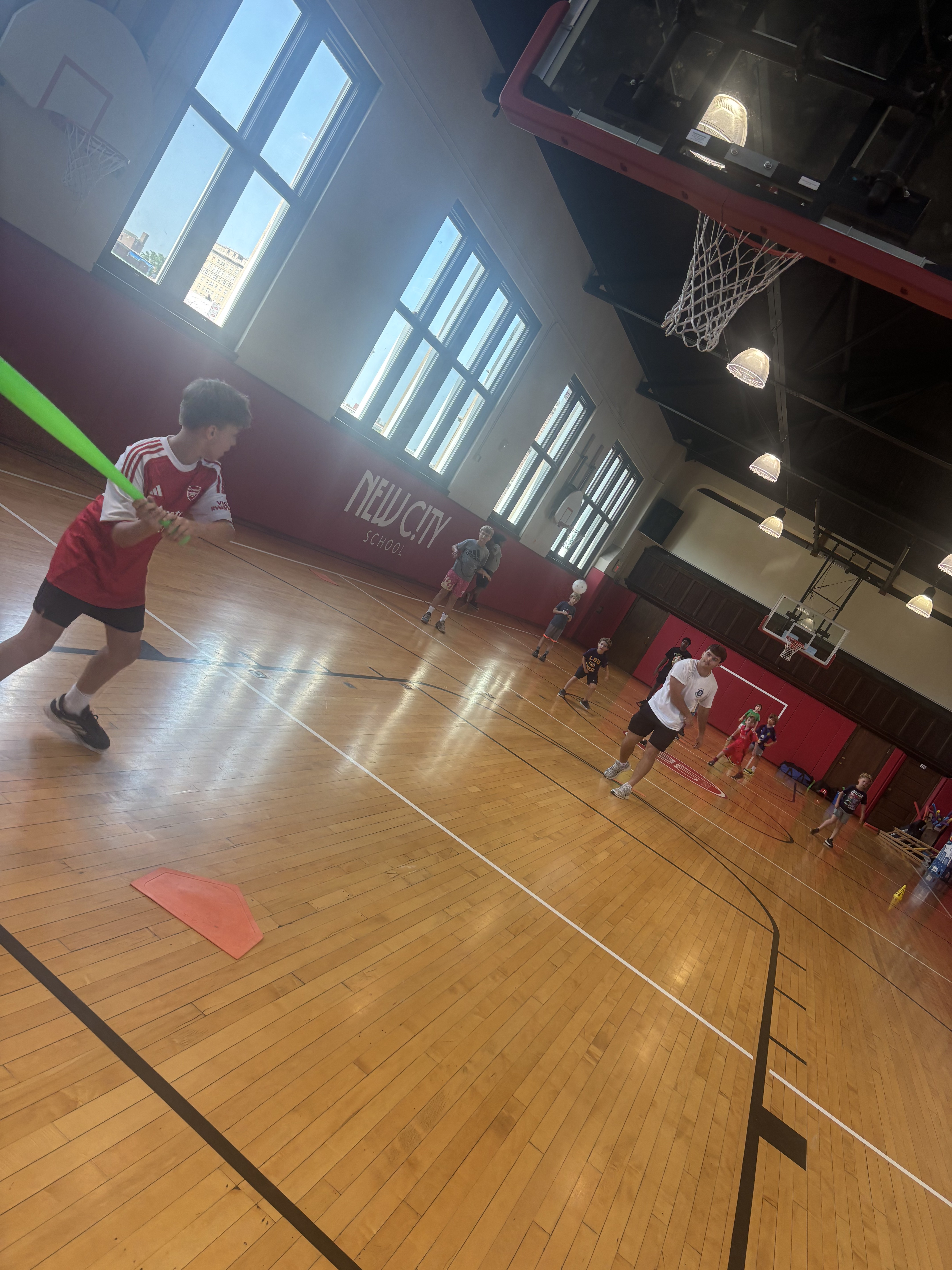 Young player taking a big swing during a Recreation Academy wiffle ball game