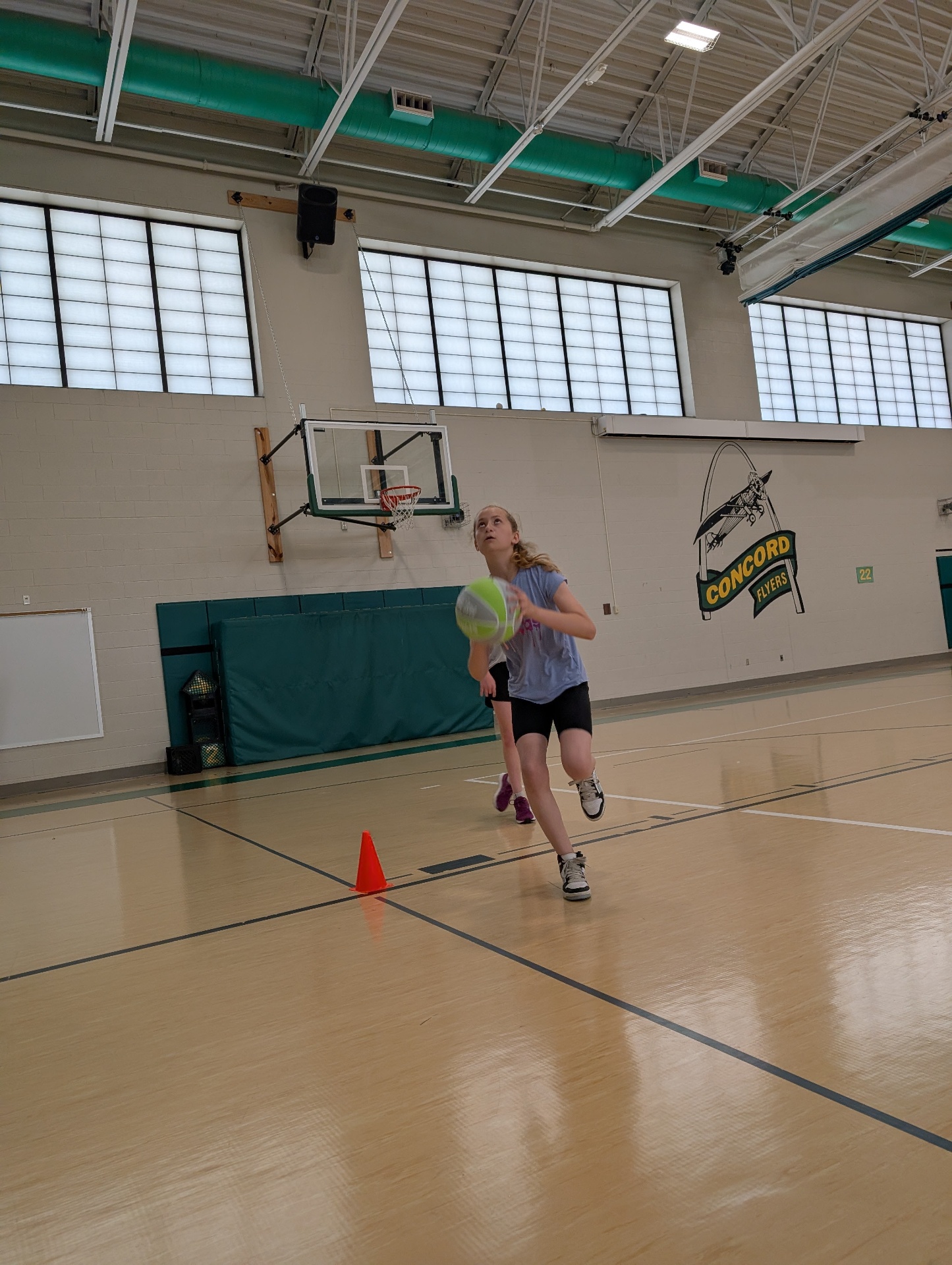Young player taking a focused basketball shot during a clinic
