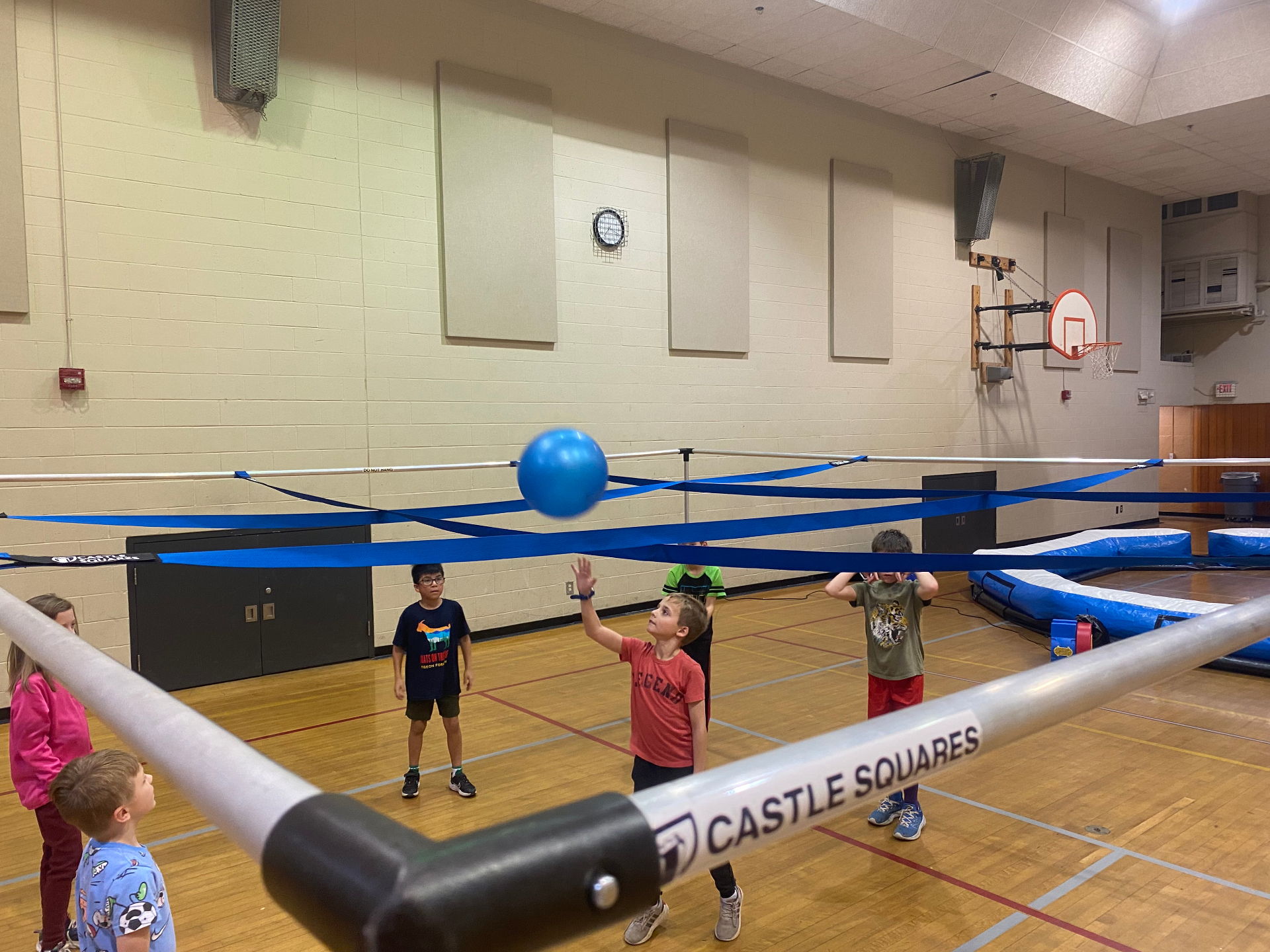 Kids playing 9 Square in the Air on a gym floor