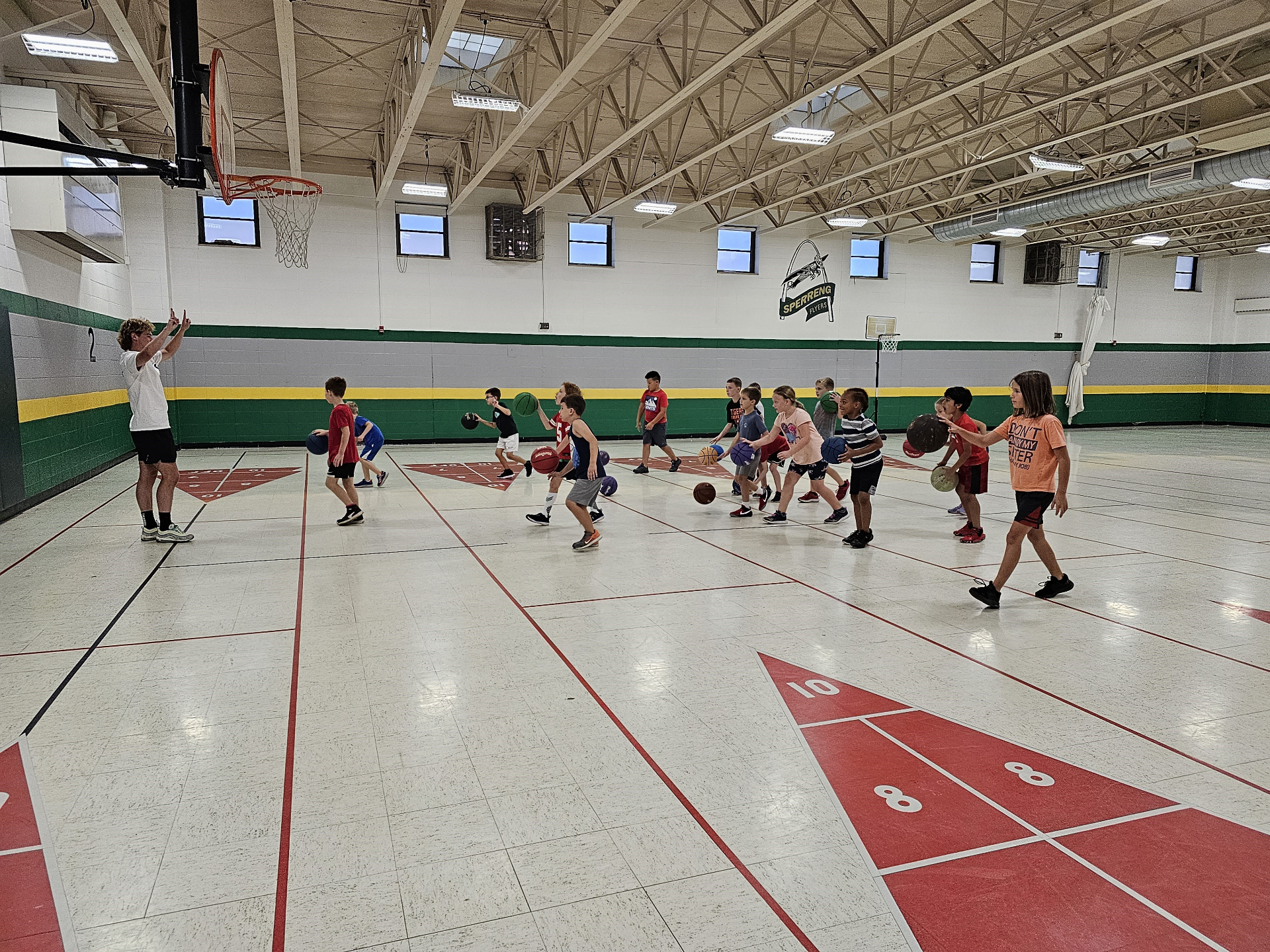 Coach Elliot leading a full-gym basketball drill
