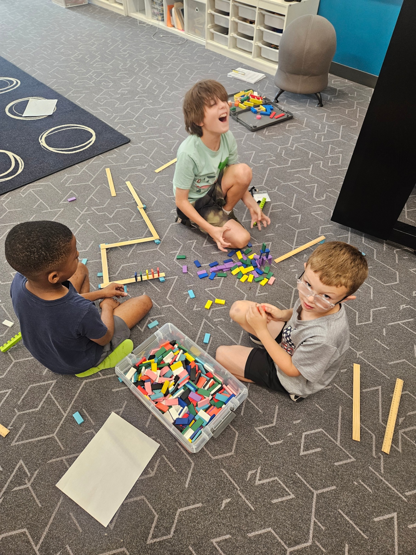 Kids laying out a large domino build together