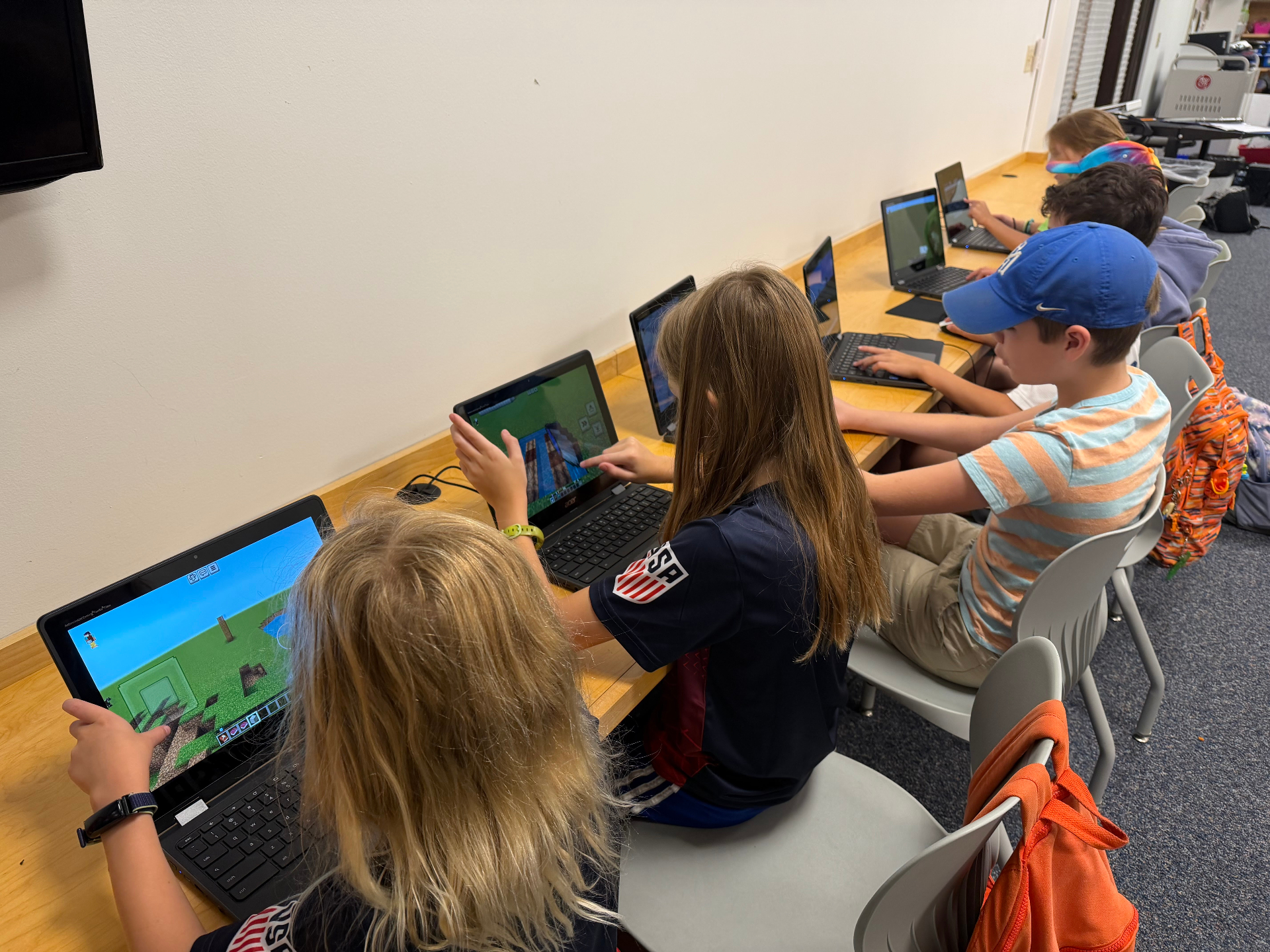 Kids collaborating on laptops during a Recreation Academy Minecraft Camp