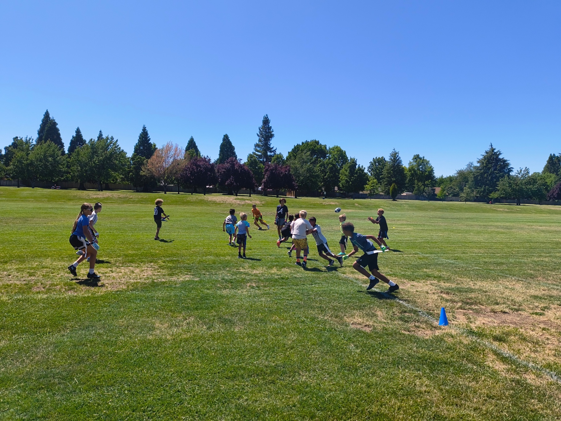 Kids sprinting during a Recreation Academy flag football session